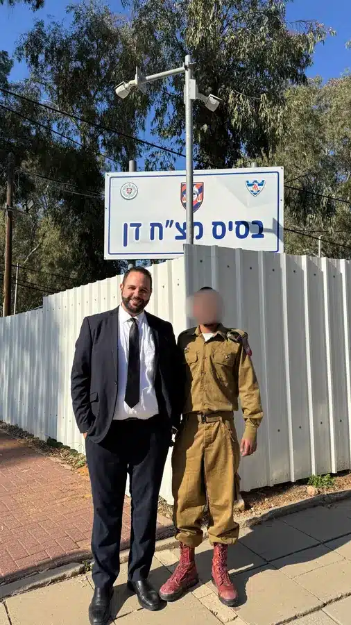 עו"ד אופיר ברמלי עם חייל שליווינו, מחוץ לבסיס מצ"ח דן. פני החייל מטושטשות